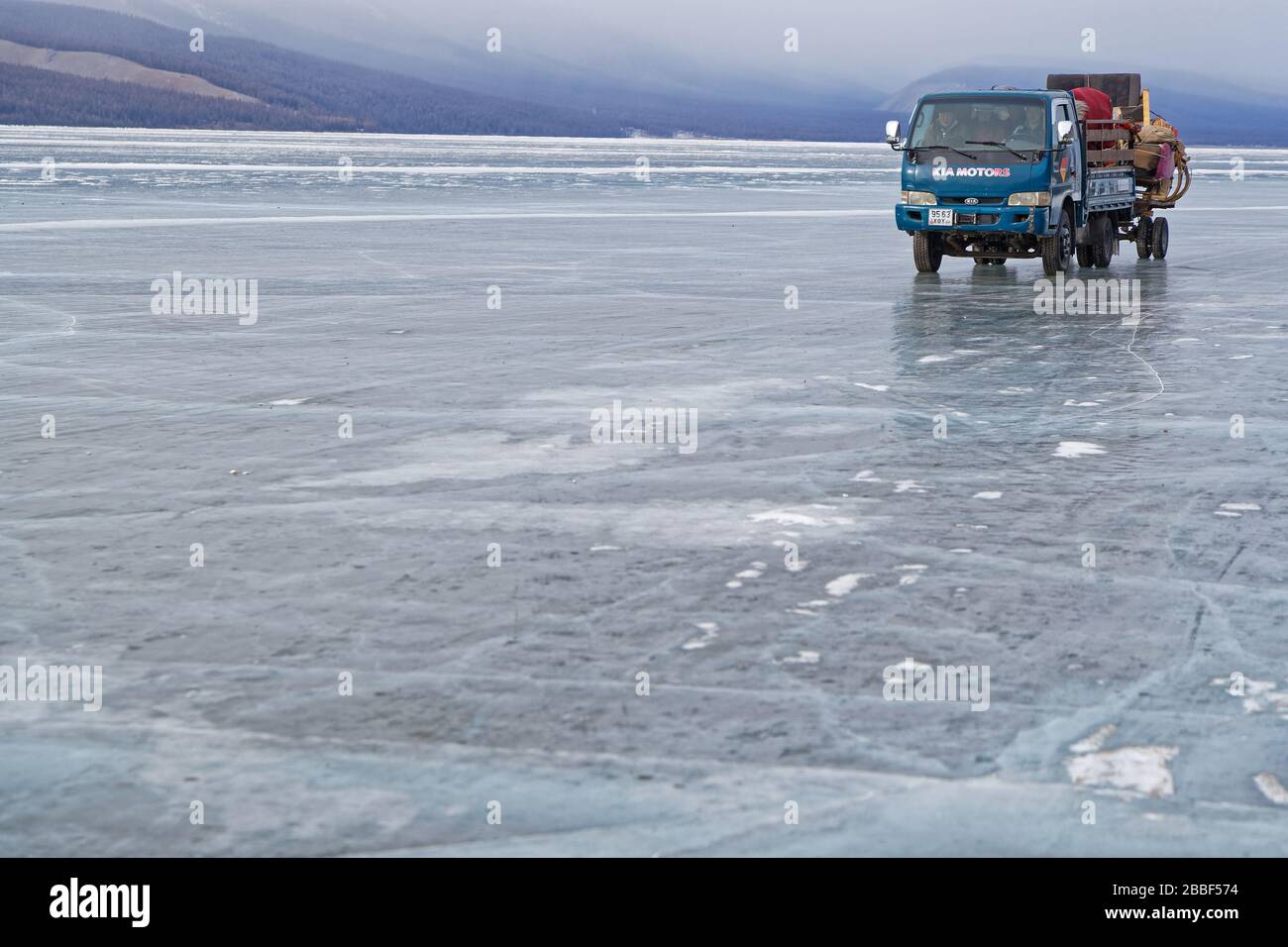 KHATGAL, MONGOLIA, 23 febbraio 2020 : un allevatore porta i suoi cavalli in un camion sul lago ghiacciato. In inverno, il lago è la strada più comune per nort Foto Stock