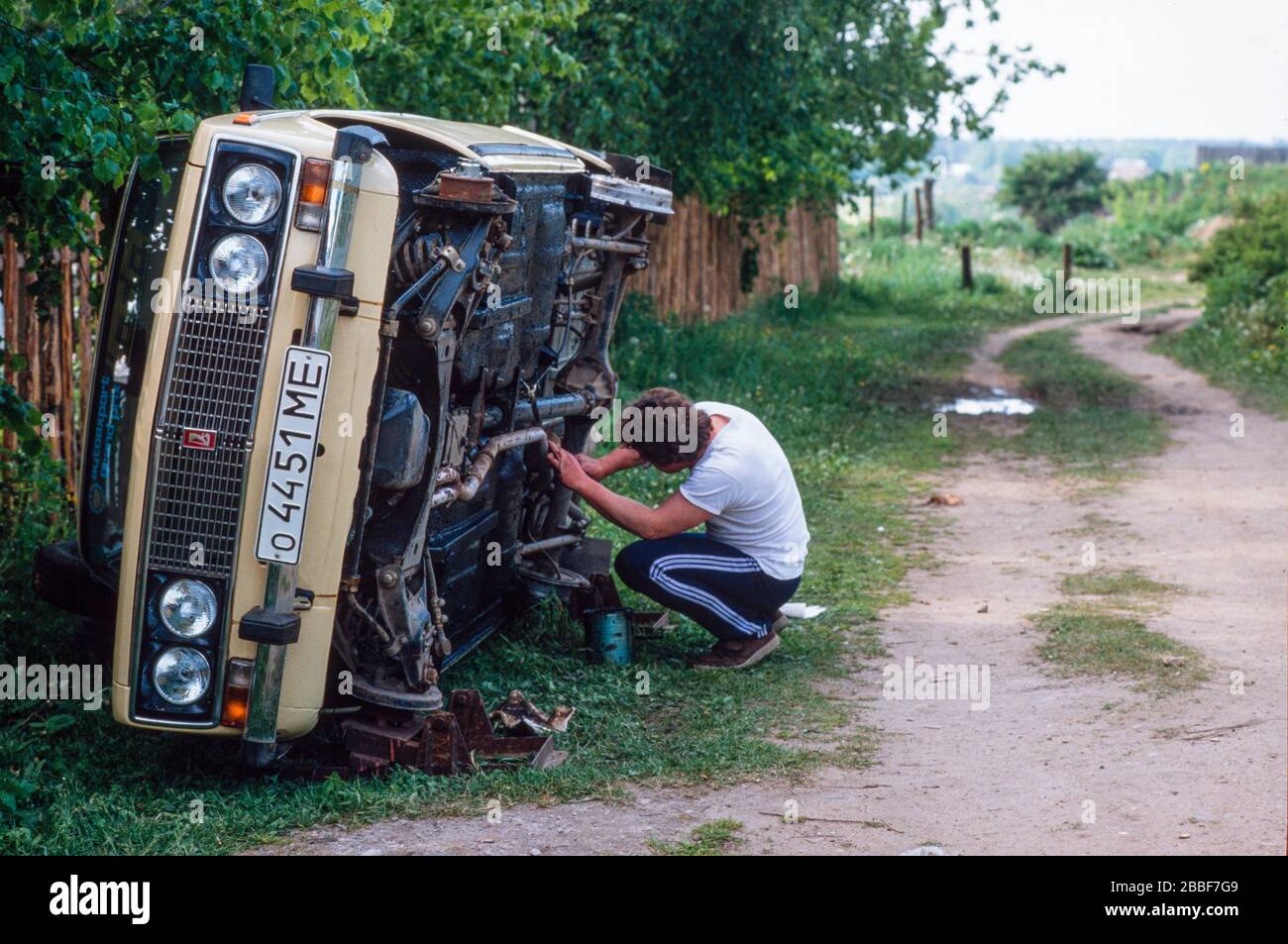 Un uomo che lavora sulla sua macchina Lada, nella città di Sergiyev Posad, formalmente Zagorsk, a 70 km da Mosca. Foto Stock
