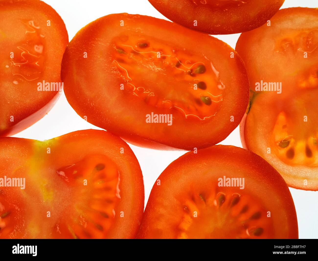 Fette di pomodoro rosso maturo su sfondo bianco Foto Stock