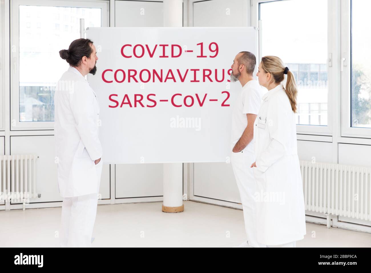 una conferenza o un incontro con il brainstorming di un gruppo di personale ospedaliero o scienziati, concetto di virus corona o covid-19, sars-cov-2 Foto Stock