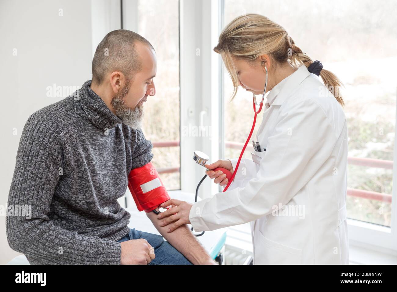 il medico femminile sta facendo un esame con un paziente maschio, concetto di virus corona o covid-19, sars-cov-2 Foto Stock