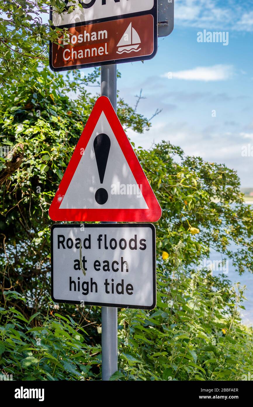 Nota: "Inondazioni stradali ad ogni alta marea", a Bosham Channel, un villaggio costiero, Chichester Harbour sulla costa sud, Chichester distretto di West Suss Foto Stock