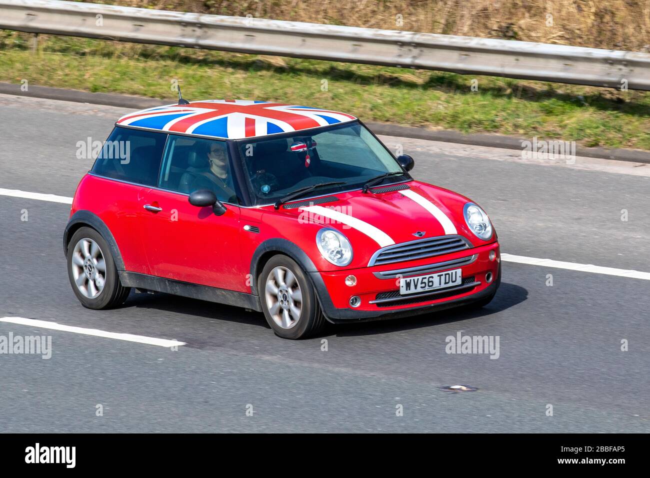 2006 Custom Red White Mini Cooper 1598 cc manuale a 5 velocità; veicoli grafici sul tetto Union Jack, berline personalizzate, guida di veicoli, strade e motori, guida in auto in direzione sud sull'autostrada M6, Regno Unito Foto Stock