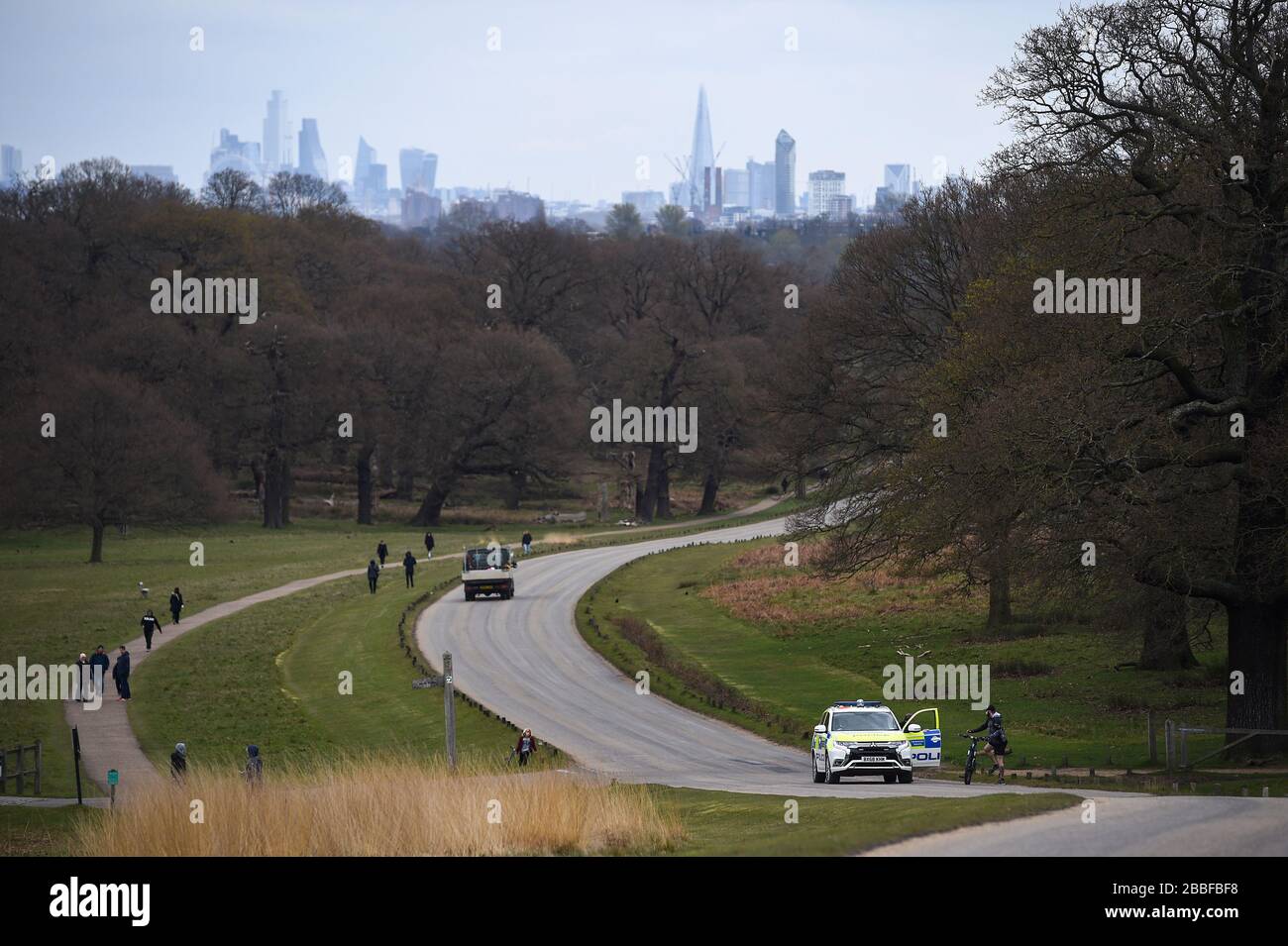 Una pattuglia di polizia si ferma per parlare con un ciclista a Richmond Park, a Richmond, sul Tamigi, a sud-ovest di Londra, mentre il Regno Unito continua a bloccarsi per contribuire a frenare la diffusione del coronavirus. Foto Stock