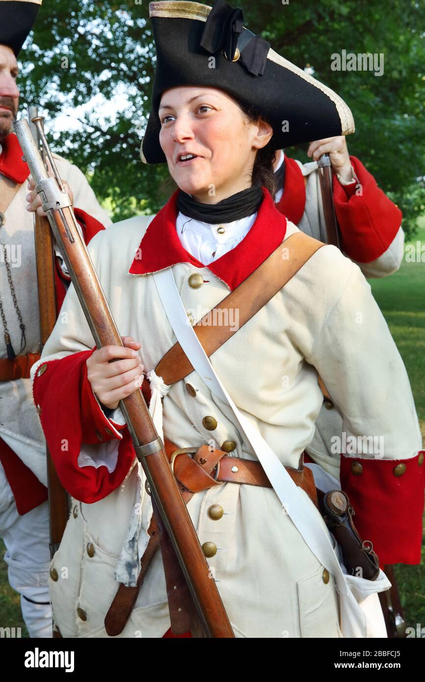 Come parte del Fetes de la Nouvelle-France (Festival della Nuova Francia), una giovane donna si prepara a prendere parte ad una parata che indossa l'uniforme del Reggimento de Bearn dell'esercito francese, originariamente inviato nel 1755 per difendere Fort Frontenac a Quebec City, provincia di Quebec, Canada Foto Stock