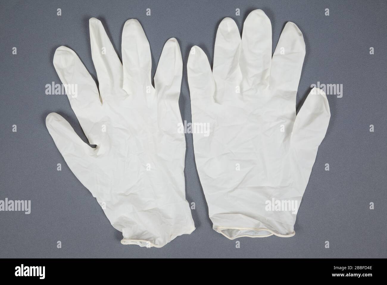 Guanti medici su sfondo grigio Foto Stock