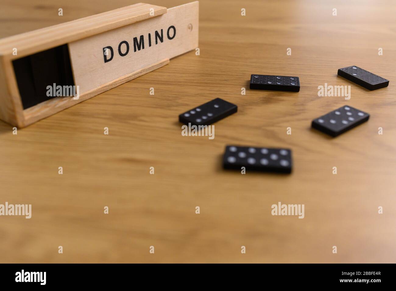 domino set nero con piastrelle in scatola di legno su sfondo di legno Foto Stock