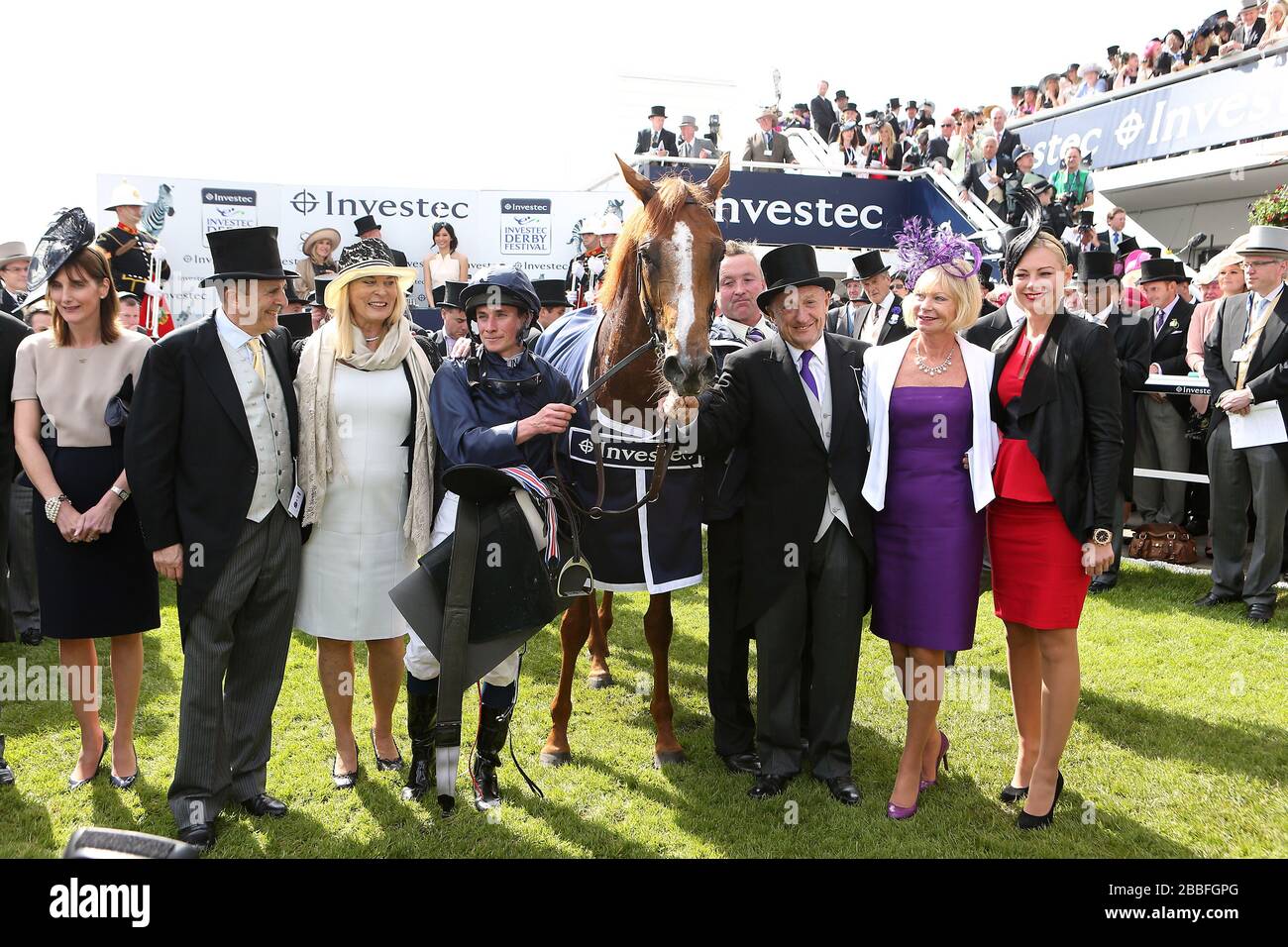 Il governatore del mondo co-proprietari Michael Tabor (seconda a sinistra) e Derrick Smith (terza a destra) con il fantino Ryan Moore (quarta a sinistra) dopo la vittoria nel Derby Investec Foto Stock