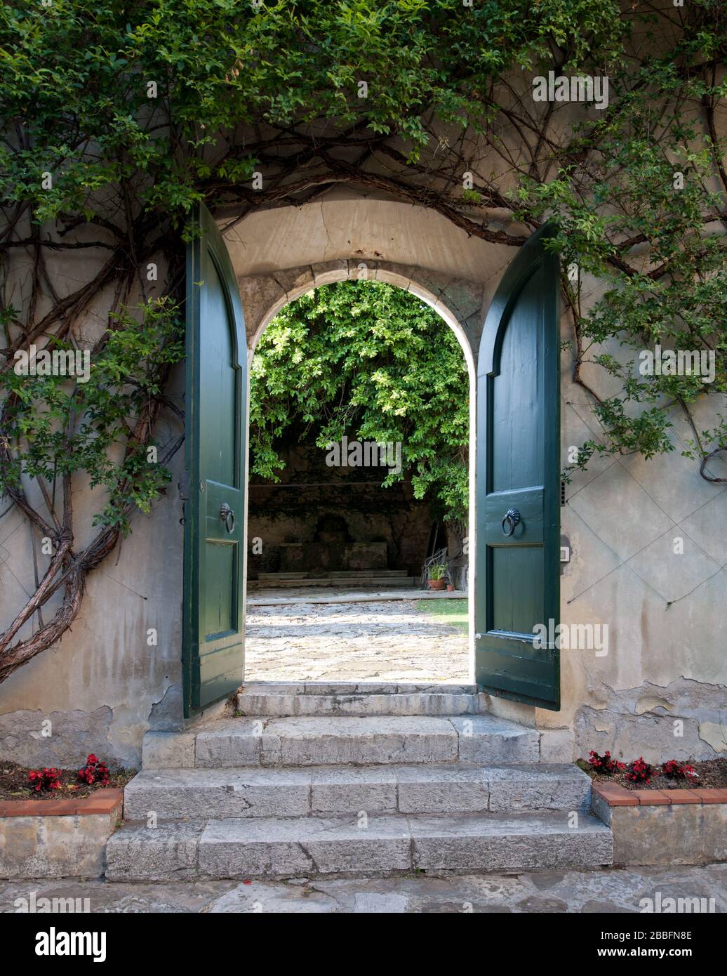 Porta verde aperta al giardino murato nella storica Villa Toscana Foto Stock