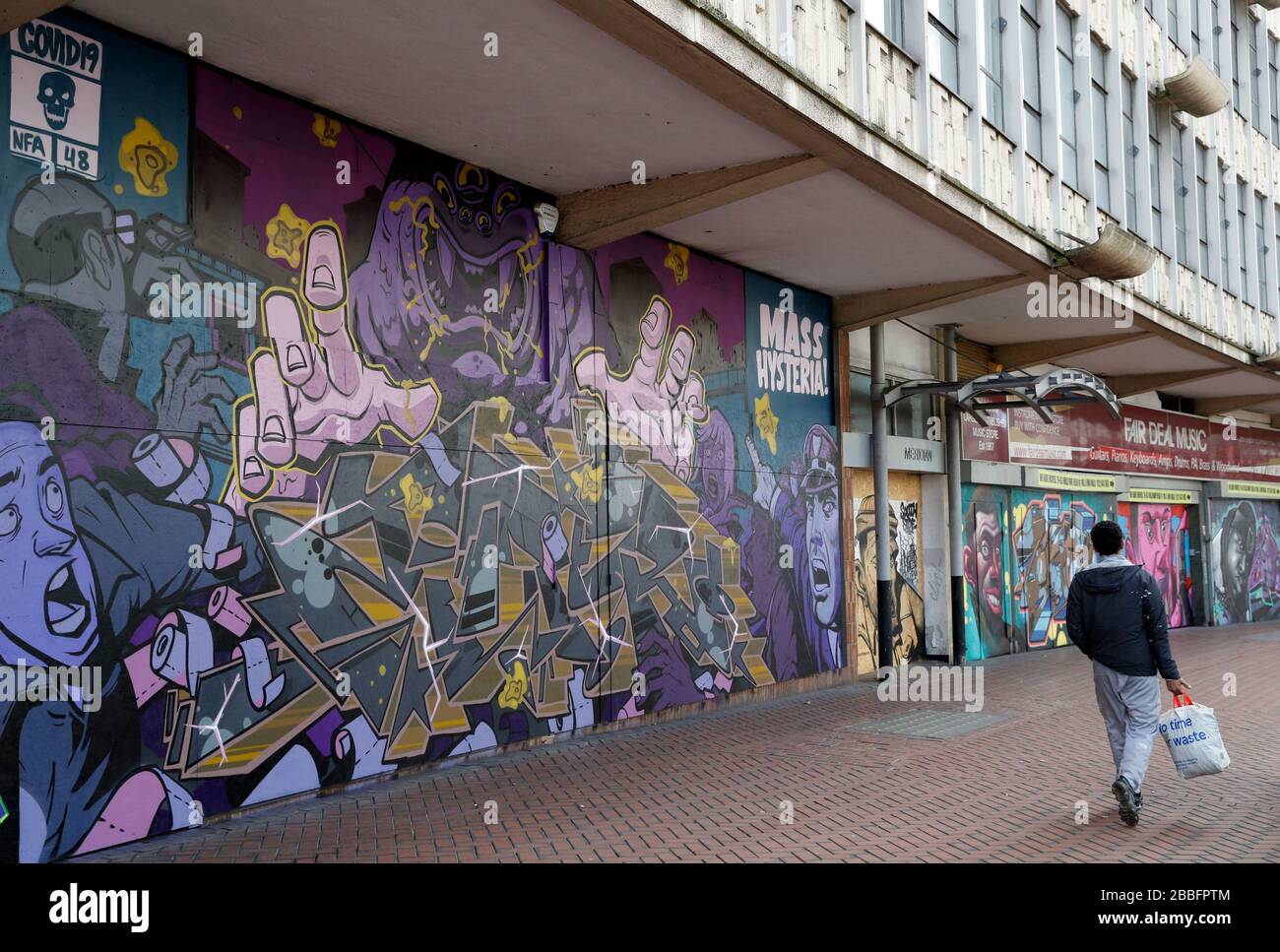 Birmingham, West Midlands, Regno Unito. 31st marzo 2020. Un uomo cammina oltre l'arte di strada di Covid-19 nel centro della città di Birmingham durante il blocco pandemico di Coronavirus. Credit Darren Staples/Alamy Live News. Foto Stock