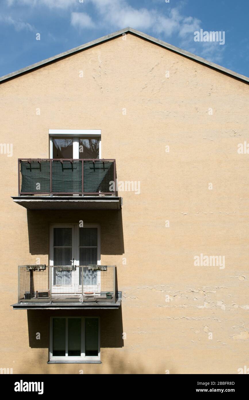 edificio di appartamenti dipinto di giallo con finestre e balcone alla luce del sole Foto Stock