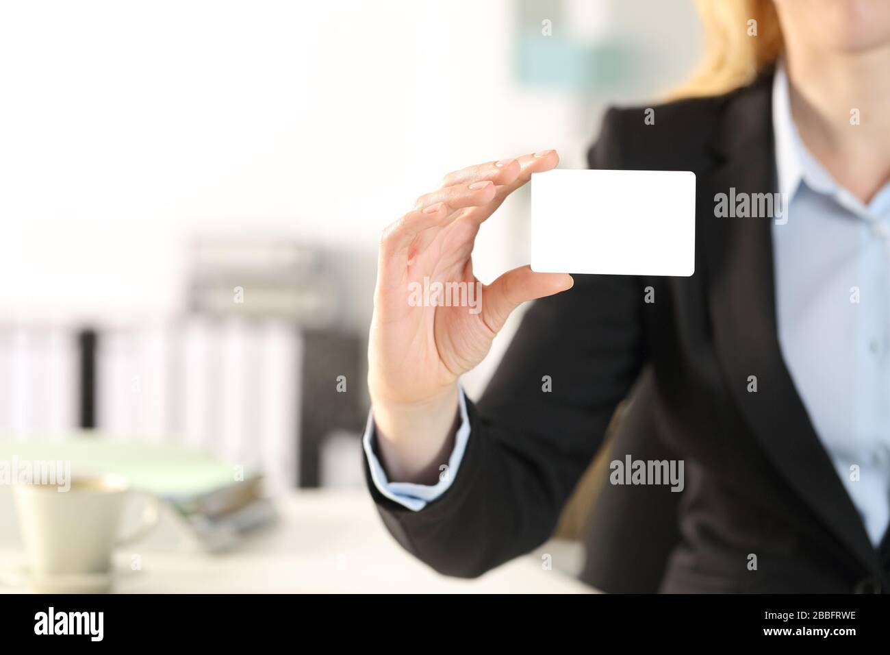 Primo piano della mano della donna di affari che mostra la carta di credito vuota all'ufficio Foto Stock