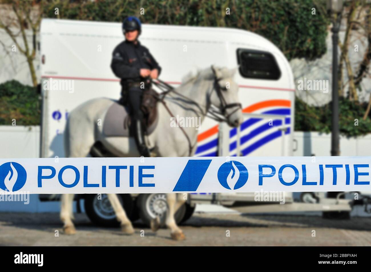 Politie / nastro di polizia di fronte al poliziotto belga montato e rimorchio di cavalli in Belgio Foto Stock