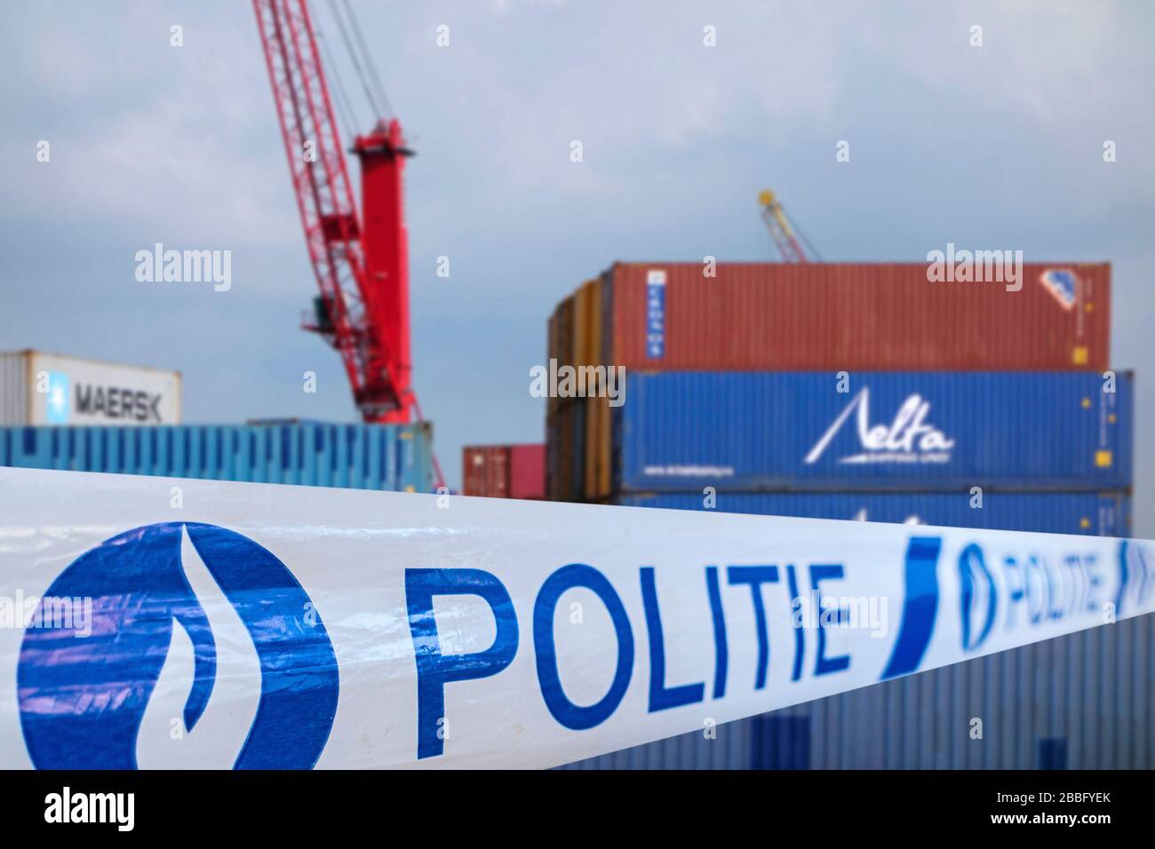 Guerra alla droga. Politie / nastro di polizia di fronte a contenitori impilati in attesa di trasporto in banchina al porto belga in Belgio Foto Stock