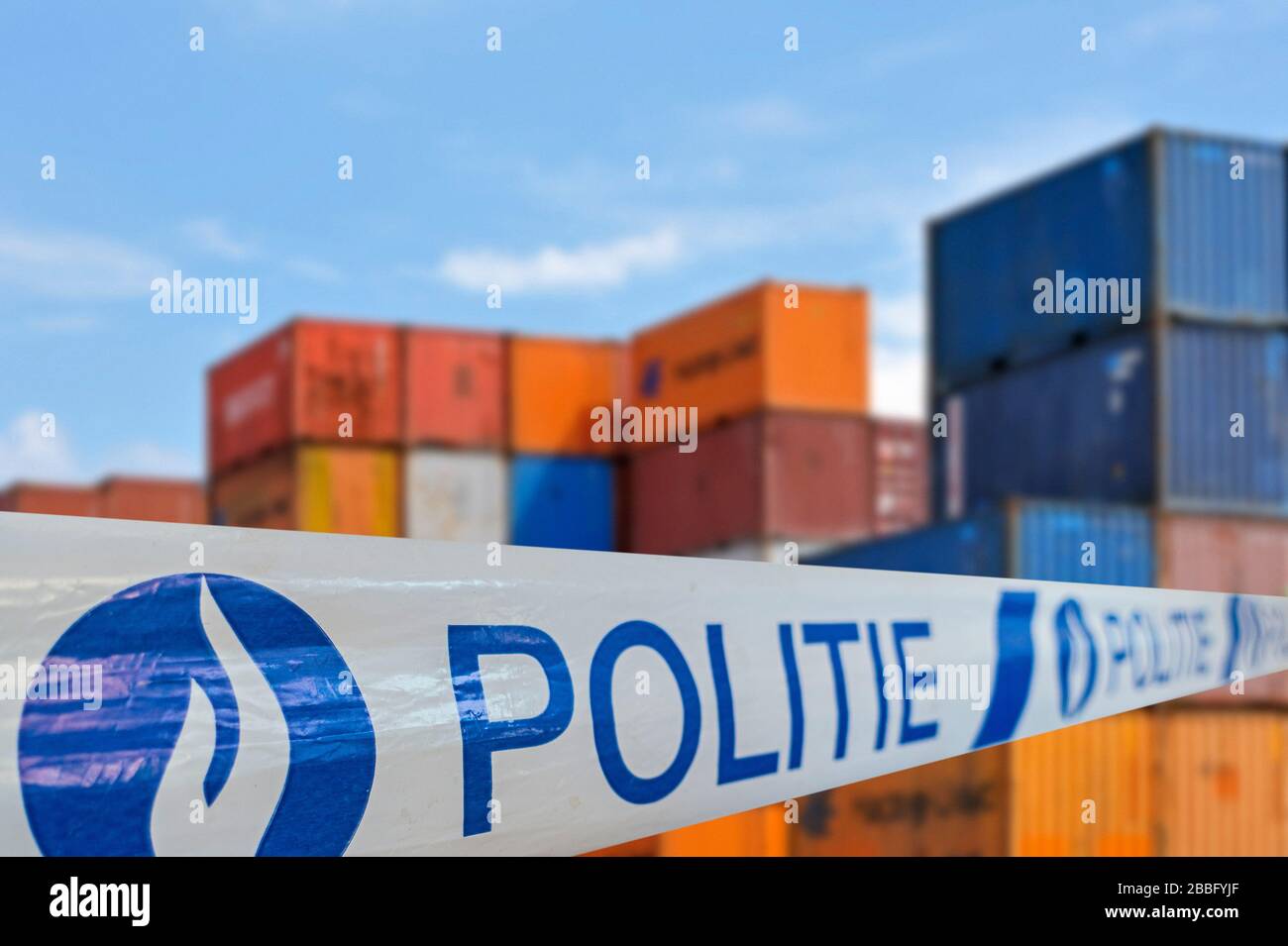 Guerra alla droga. Politie / nastro di polizia di fronte a contenitori impilati in attesa di trasporto in banchina al porto belga in Belgio Foto Stock