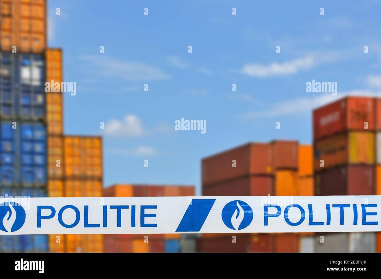 Guerra alla droga. Politie / nastro di polizia di fronte a contenitori impilati in attesa di trasporto in banchina al porto belga in Belgio Foto Stock