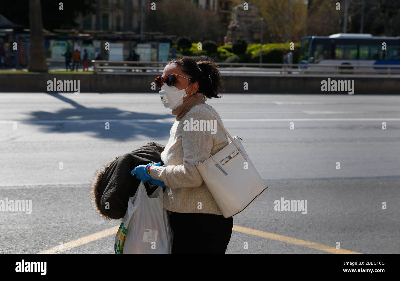 Una donna indossa un maks protettivo come una quarantena è impostata dopo l'epidemia di coronavirus (COVID-19) nell'isola turistica delle Baleari Foto Stock