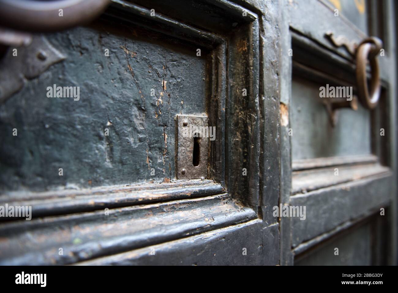 Un vecchio batticalcano metallico su una vecchia porta di legno Foto Stock