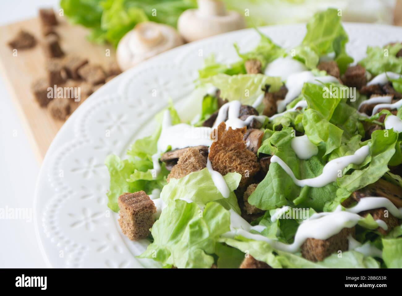 Versione vegetariana della classica insalata Caesar con funghi invece di pollo, crostini, lattuga, parmigiano e salsa Foto Stock