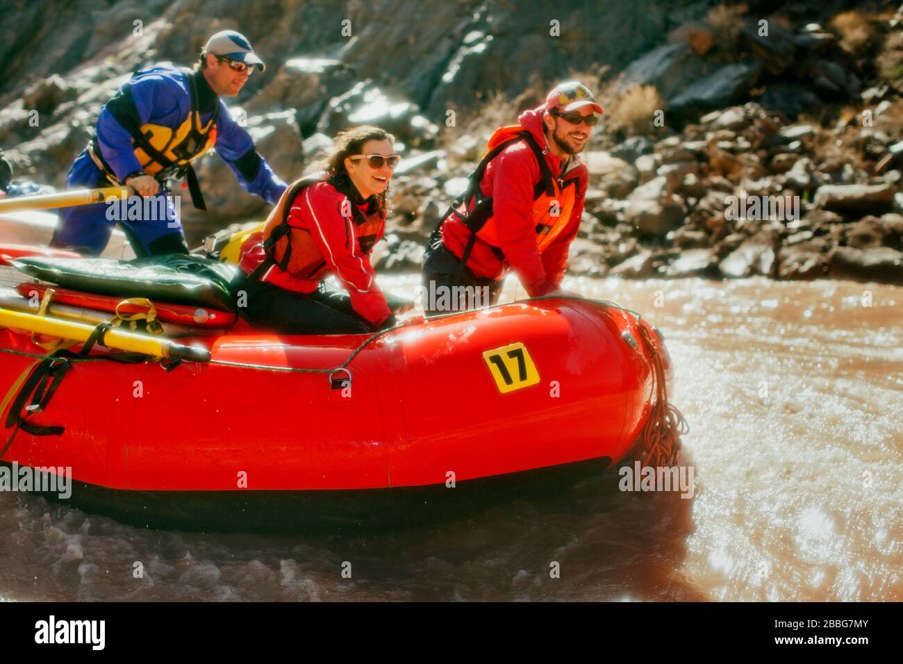 Gruppo di amici che si divertono mentre rafting su rapide in un fiume che scorre velocemente. Foto Stock