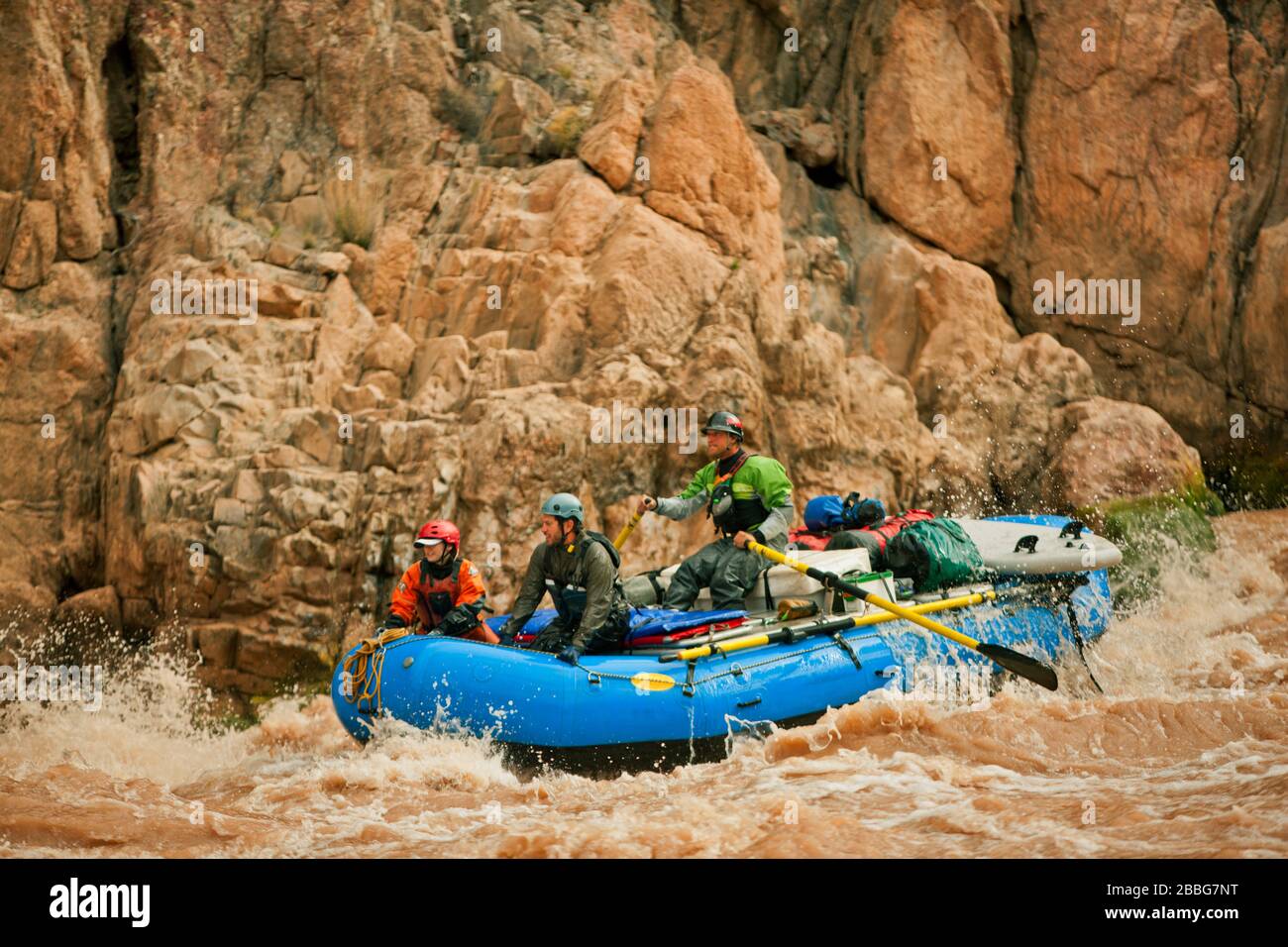 Gruppo di amici white water rafting insieme attraverso rapide in un veloce che scorre il fiume. Foto Stock