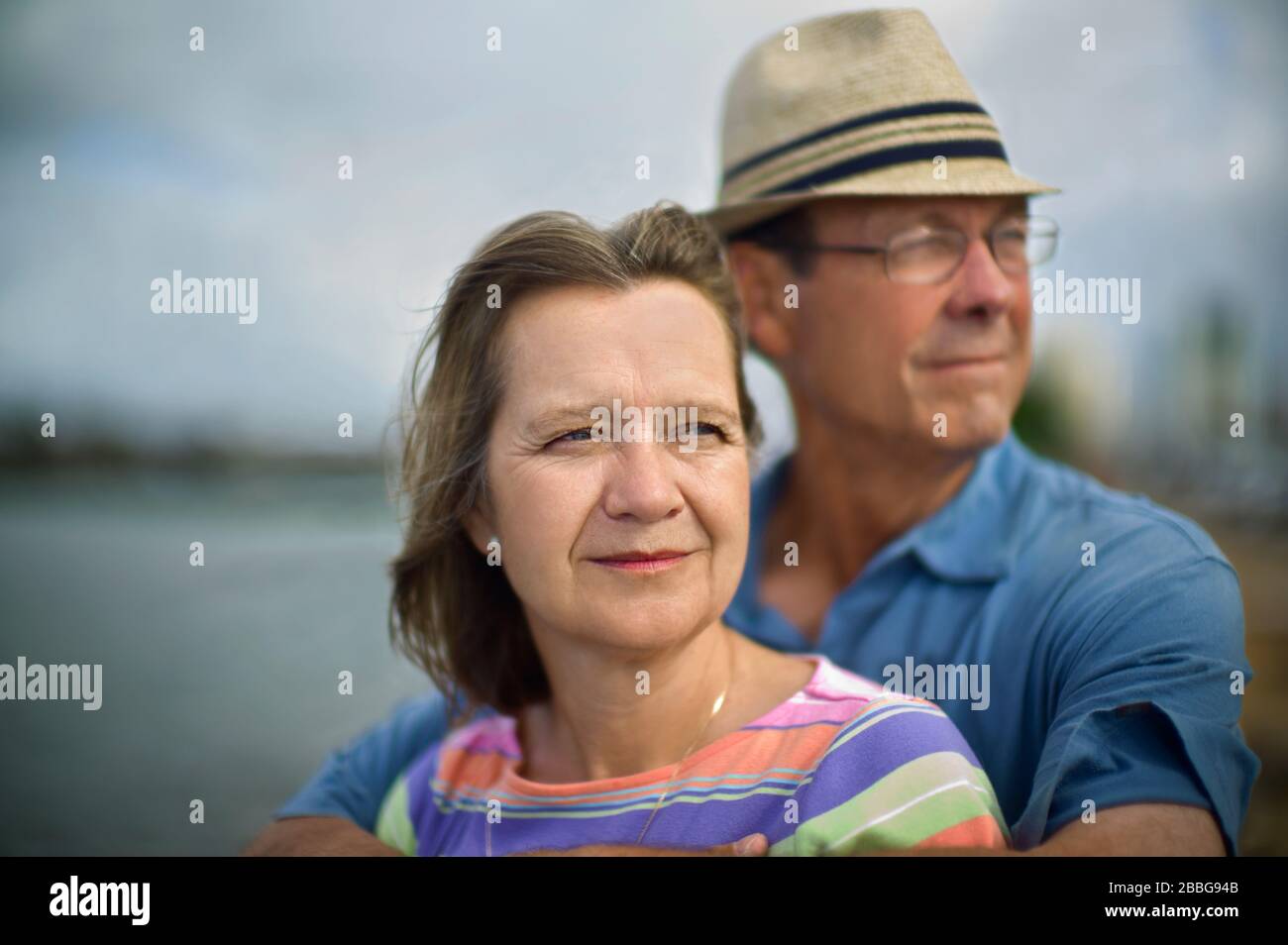 Ritratto di una coppia matura in piedi da un lago Foto Stock