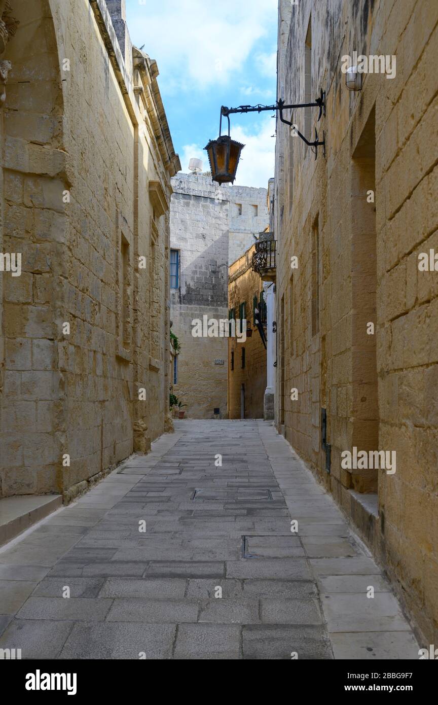 Vista su una delle tante antiche stradine medievali della città di Mdina, Malta Foto Stock