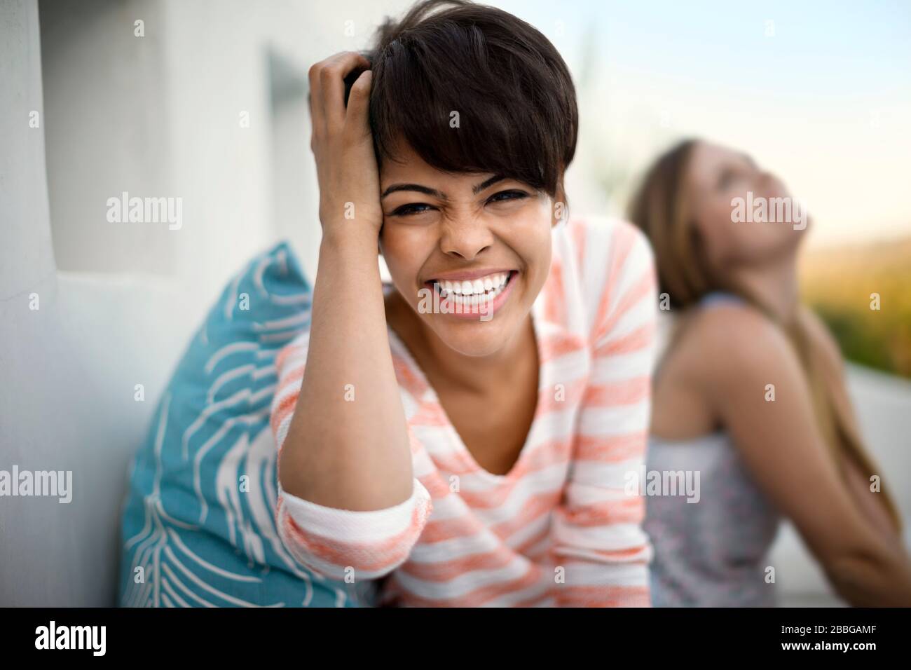 Ritratto di donna sorridente con un amico seduto sullo sfondo Foto Stock