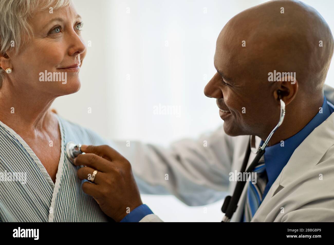 Donna matura che ha il suo battito cardiaco controllato dal suo medico Foto Stock