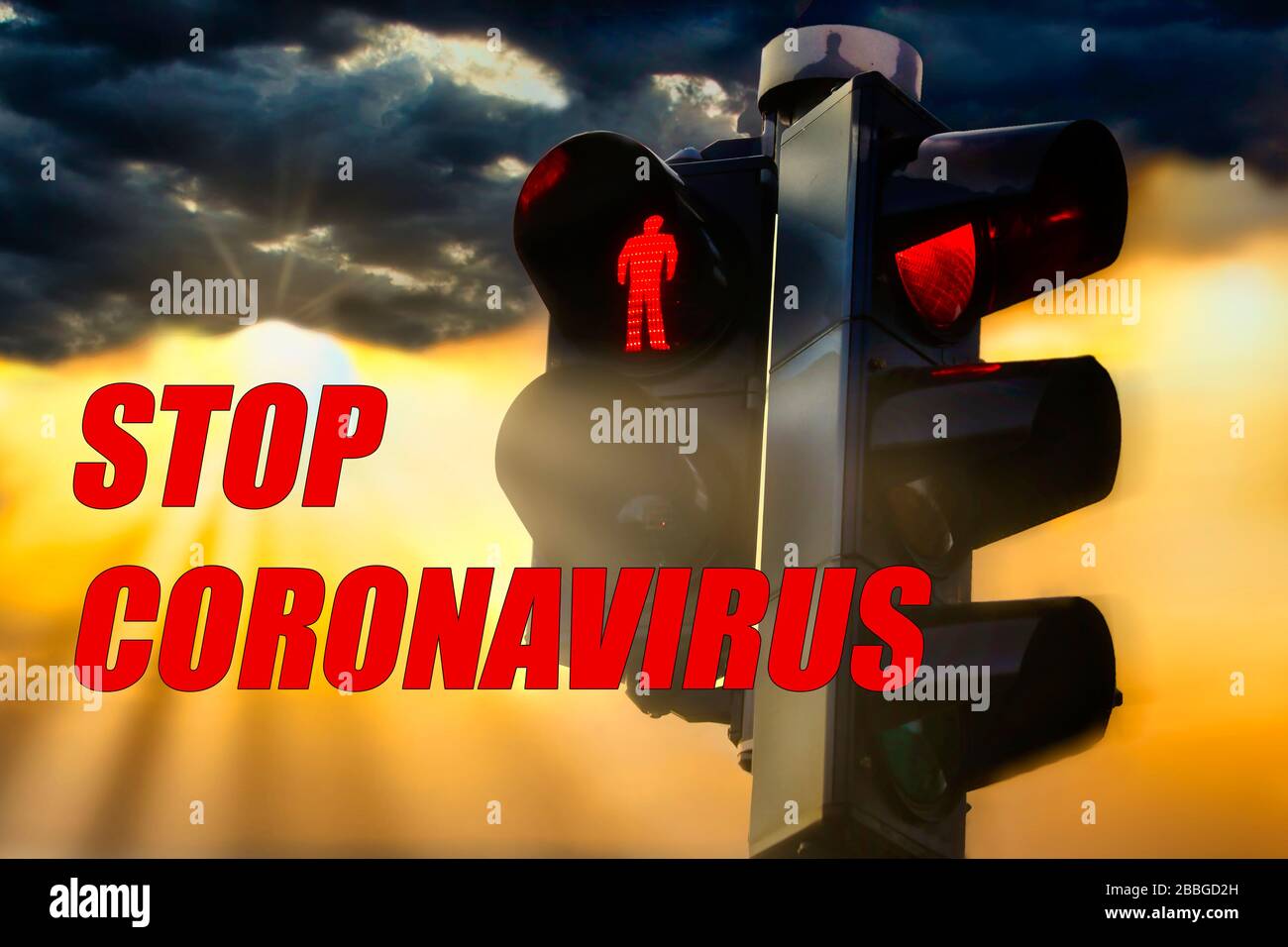 Stop Coronavirus Concept con semaforo rosso illuminato e sfondo cielo scuro con raggi solari. Foto Stock