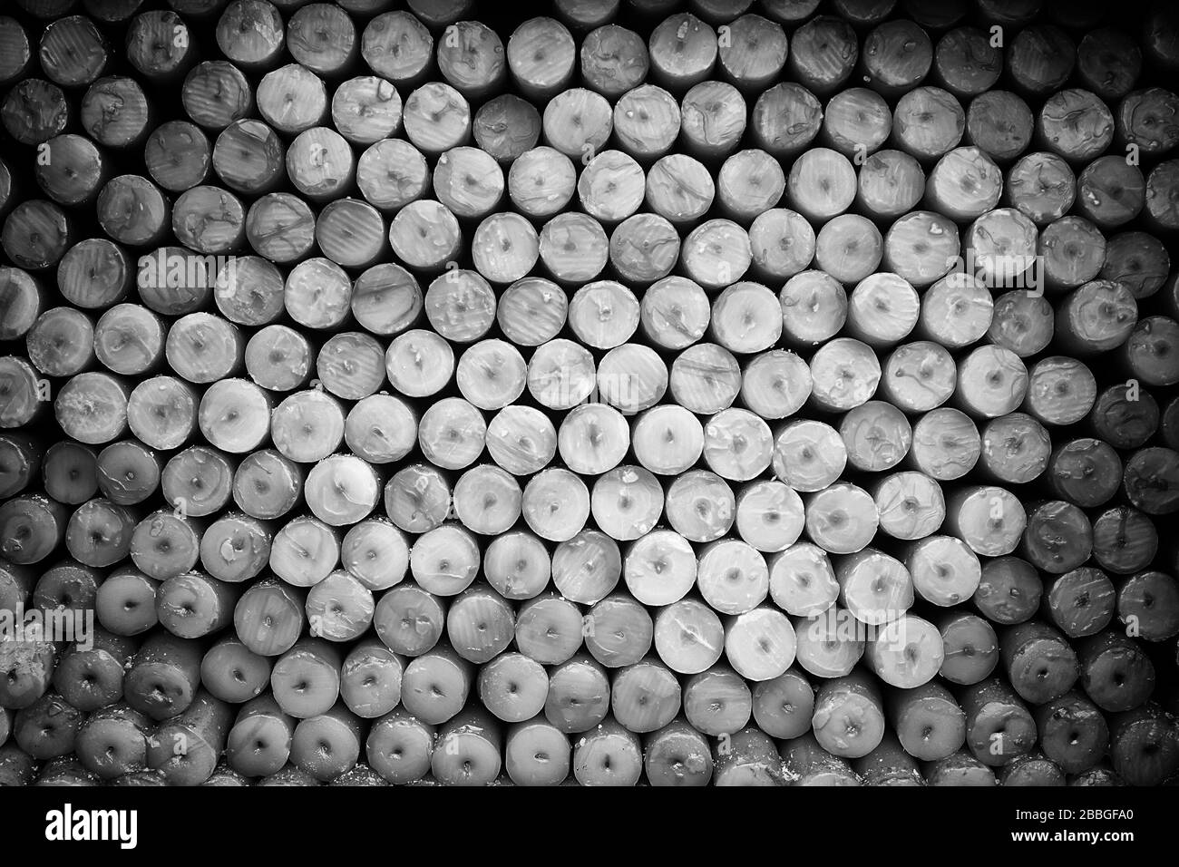 Candele impilati a Lourdes per vendere, simbolo religioso Foto Stock