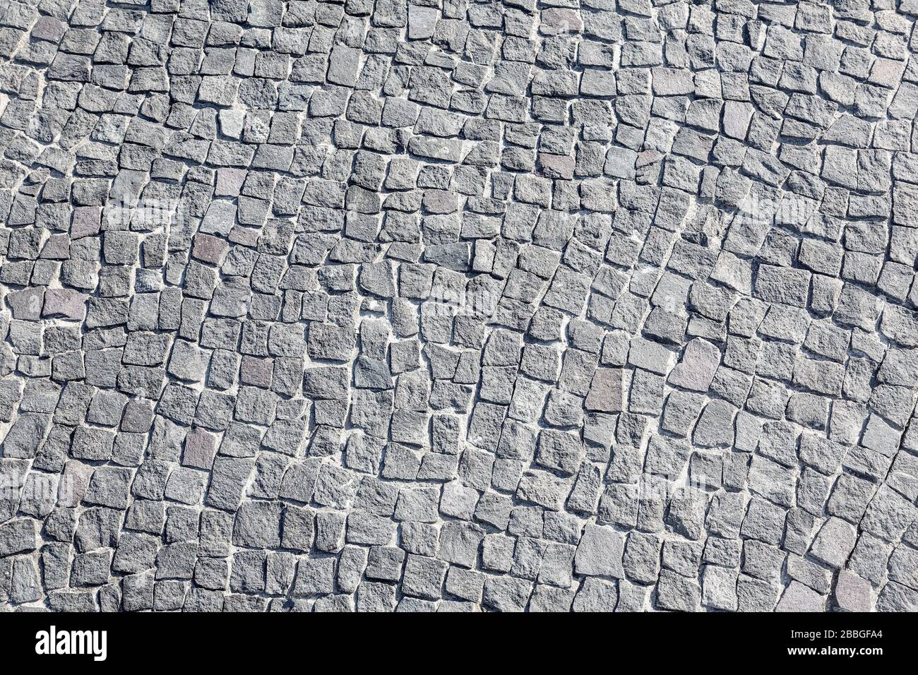 Le piastrelle in pietra per marciapiedi sono realizzate con piastrelle di forma ridotta, struttura senza cuciture Foto Stock