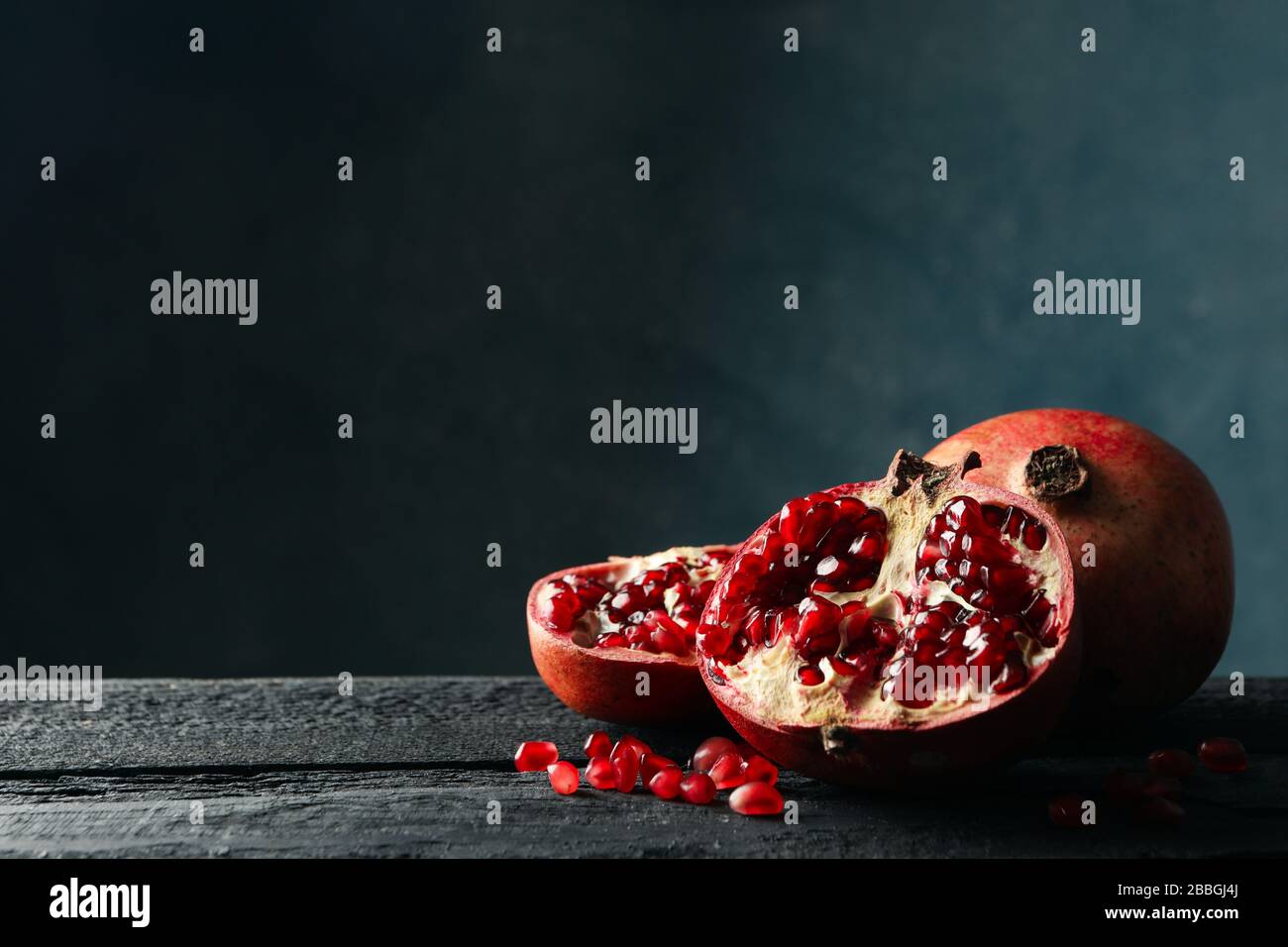 Melograno su tavola di legno, spazio per il testo. Frutta succosa Foto Stock