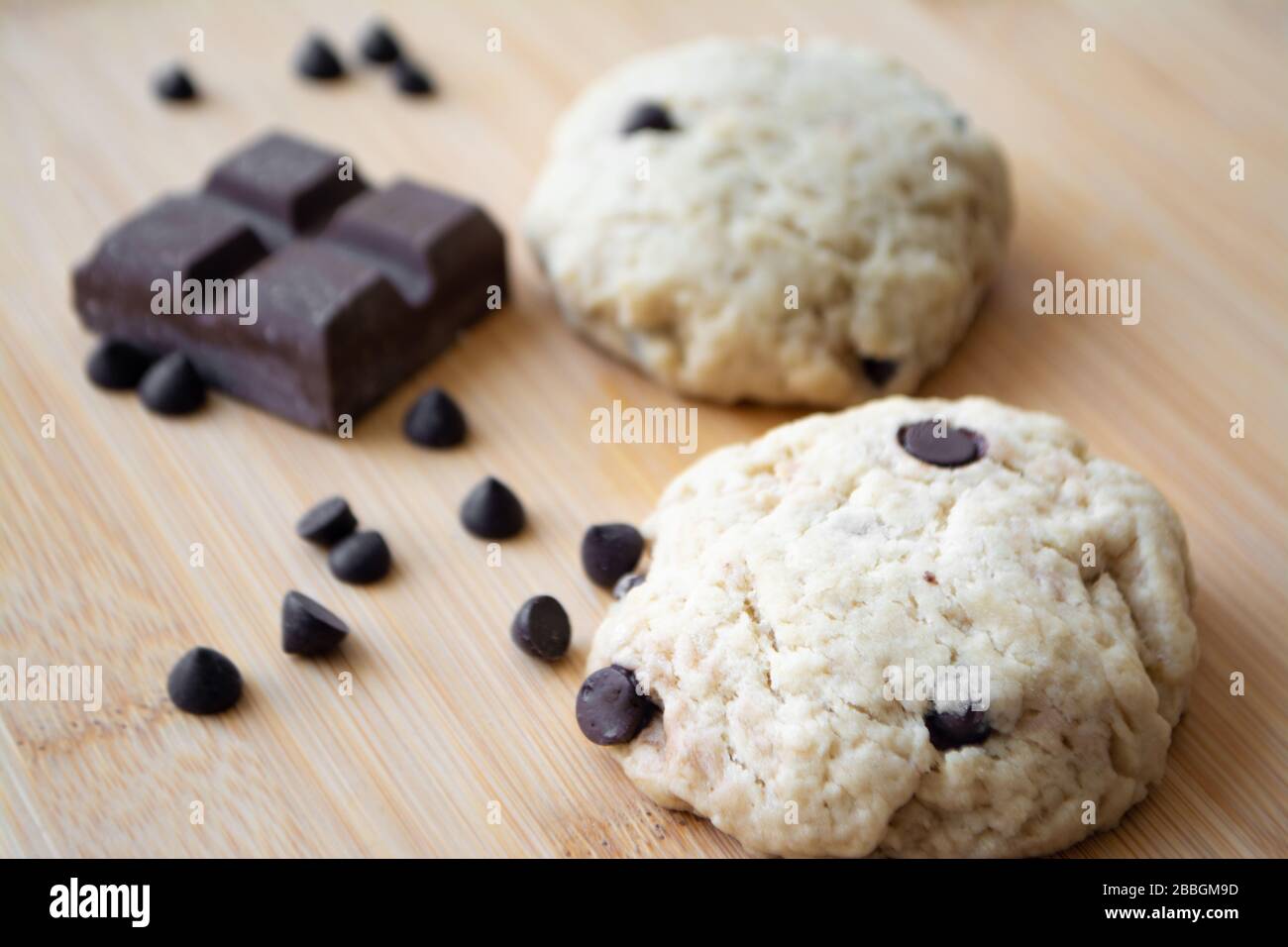 Biscotti fatti in casa con scaglie di cioccolato e cioccolato fondente sullo sfondo Foto Stock