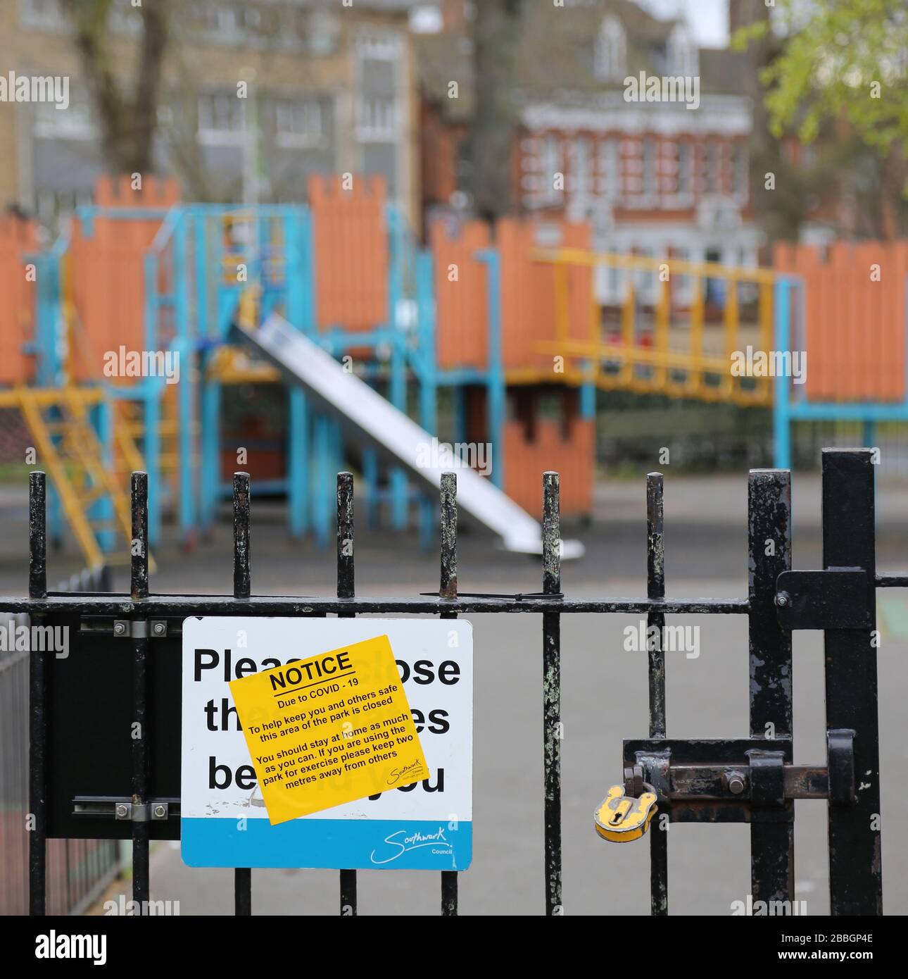 Un parco giochi per bambini rinchiuso e abbandonato nel sud di Londra, nel Regno Unito, durante lo scoppio del virus Corona del 2020. Cancelli bloccati con lucchetto, segnale di avvertimento sul cancello. Foto Stock
