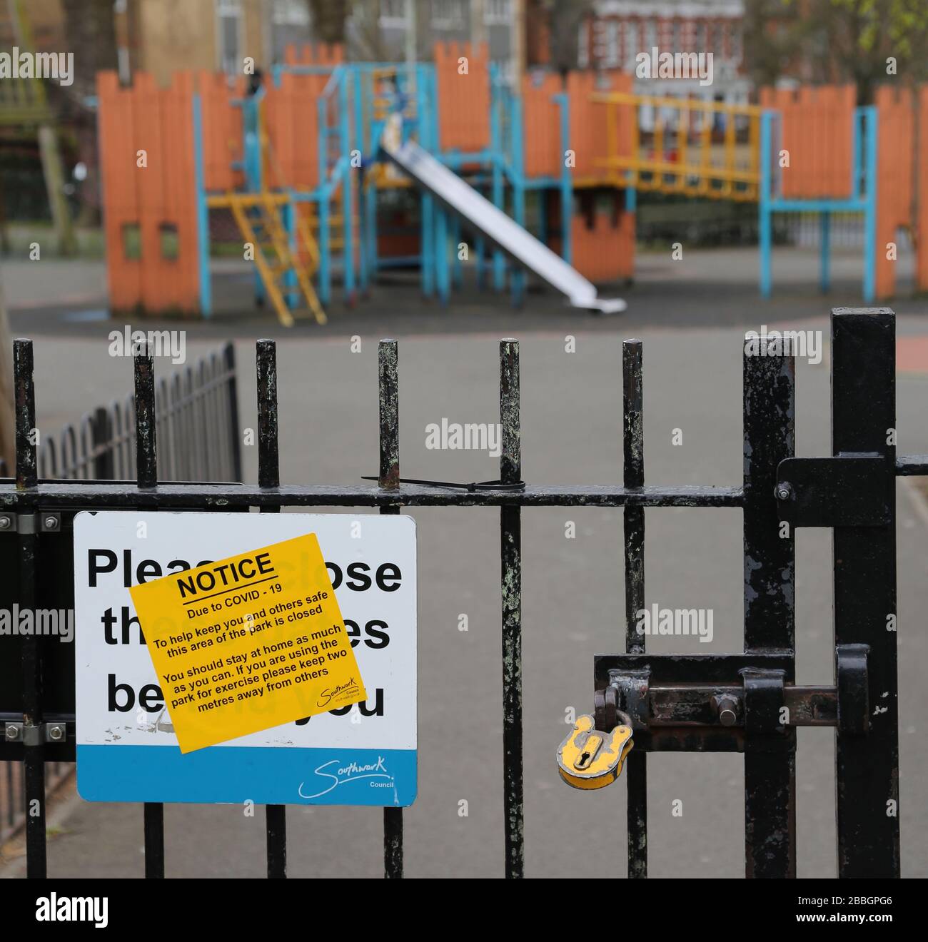 Un parco giochi per bambini rinchiuso e abbandonato nel sud di Londra, nel Regno Unito, durante lo scoppio del virus Corona del 2020. Cancelli bloccati con lucchetto, segnale di avvertimento sul cancello. Foto Stock