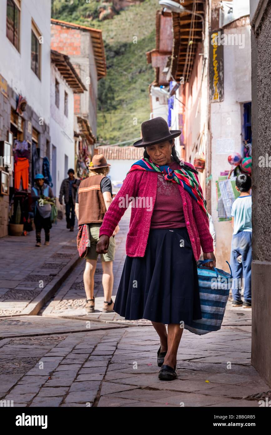 Pisac, Perù - 02.23.2020: Donna peruviana che porta una borsa per le strade di Pisac Foto Stock