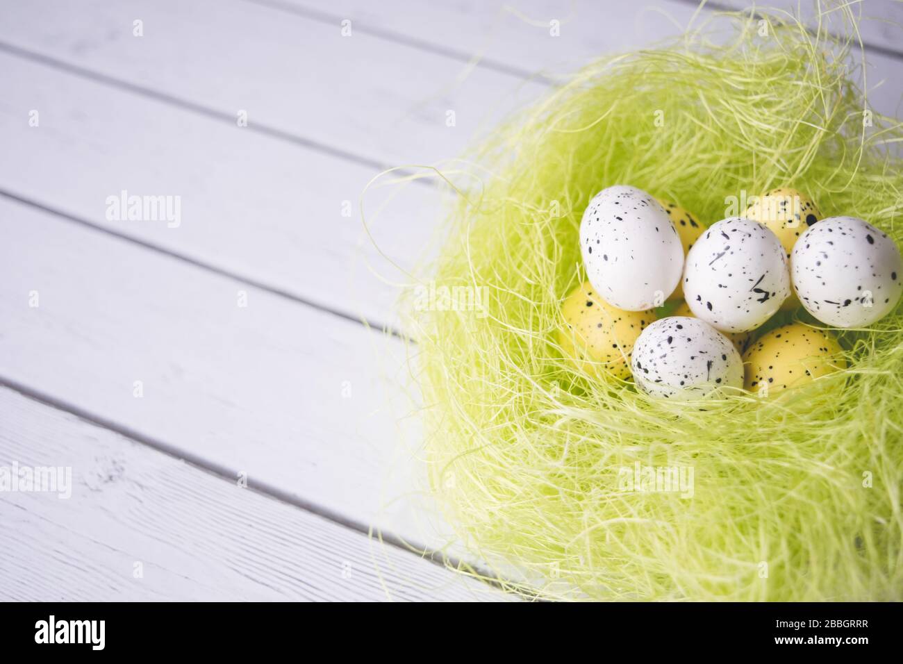 Decorazioni pasquali. Uova in nidi su sfondo di legno Foto Stock