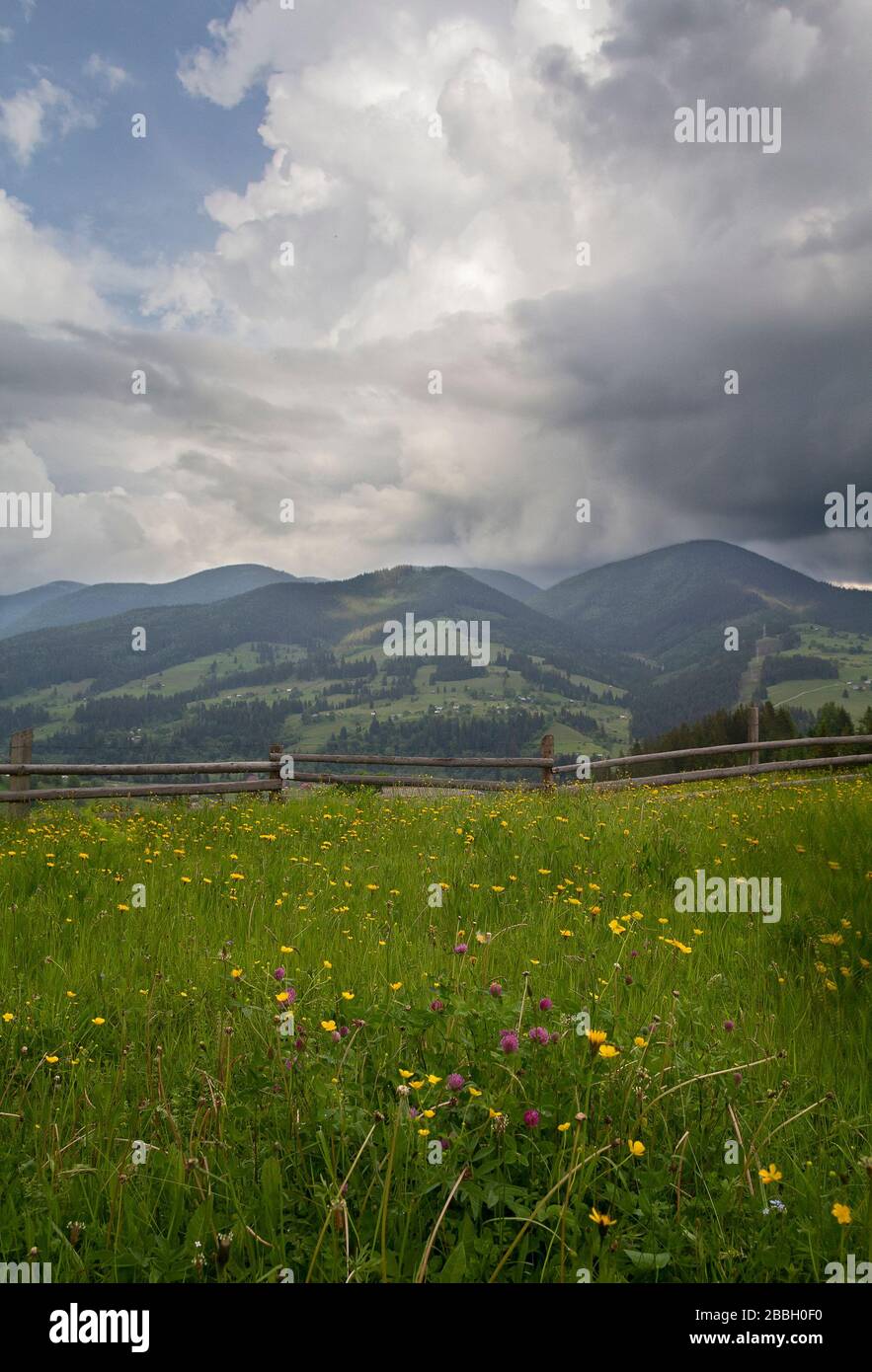 Paesaggio del villaggio con una recinzione in legno in primo piano. Carpazi Foto Stock