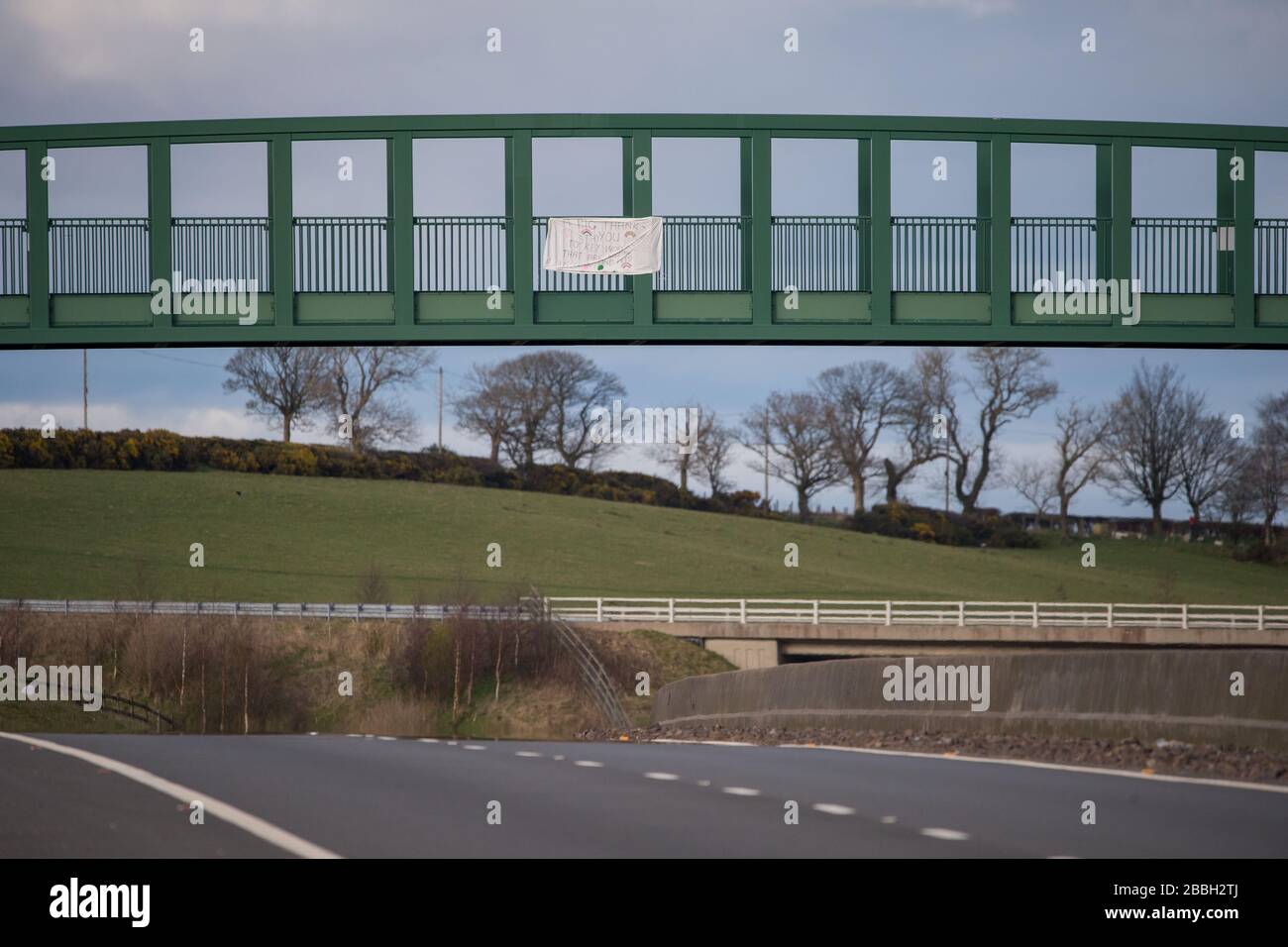 Cumbernauld, Scozia, Regno Unito. 31st Mar, 2020. Nella foto: I bambini hanno fatto un cartello fatto in casa utilizzando pennarelli colorati e un foglio di letto bianco che hanno fissato a un ponte pedonale sopra l'autostrada vicino Cumbernauld. I cartelli indicano: "UN GRANDE RINGRAZIAMENTO AI PRINCIPALI LAVORATORI CHE CI STANNO MANTENENDO AL SICURO E NUTRIRSI, STARE AL SICURO" credito: Colin Fisher/Alamy Live News Foto Stock