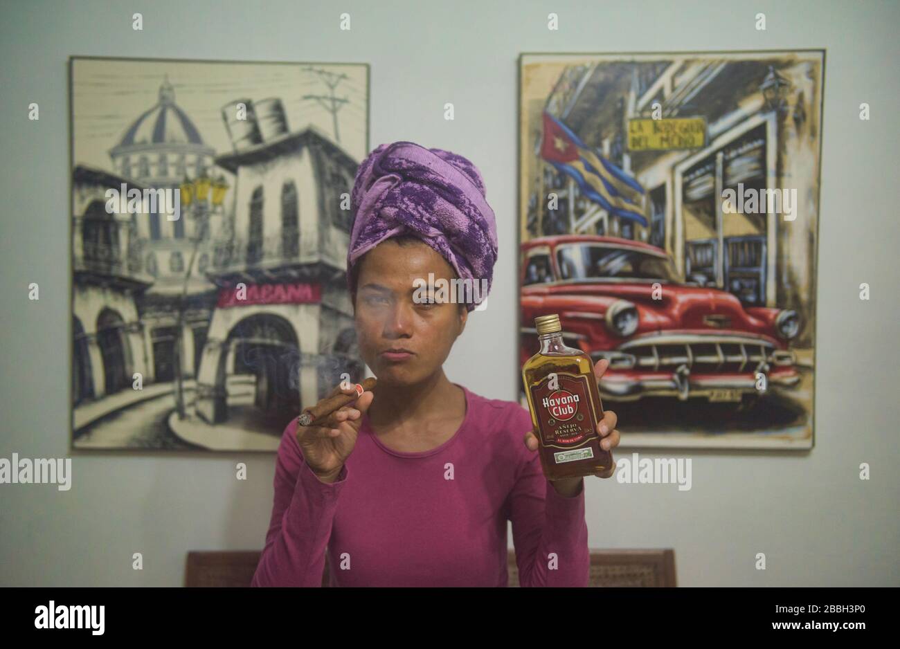 Godetevi il rum e il sigaro cubano dell'Havana Club di fronte al dipinto di El Bodeguito, l'Avana, Cuba Foto Stock