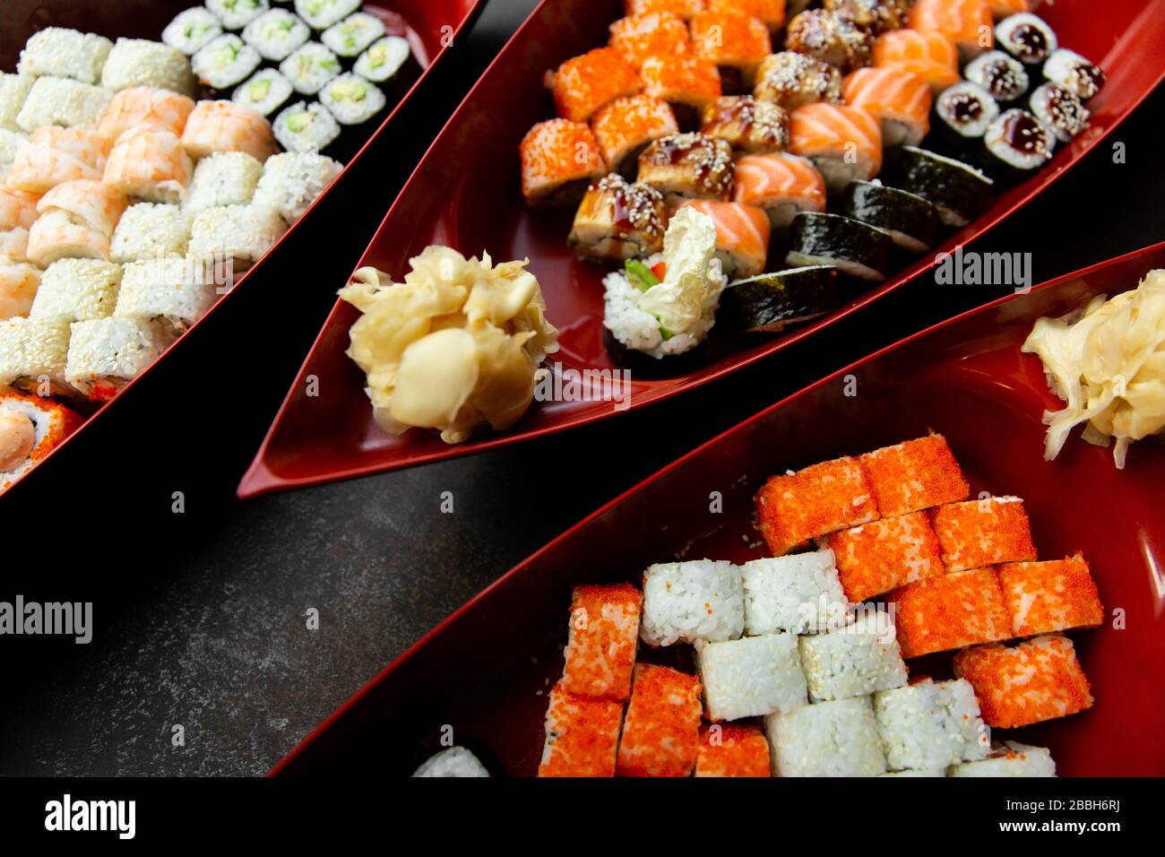 sushi giapponese cibo. Vari tipi di sushi servito su una barca vicino. Grande serie di panini su un piatto in un ristorante. Foto Stock