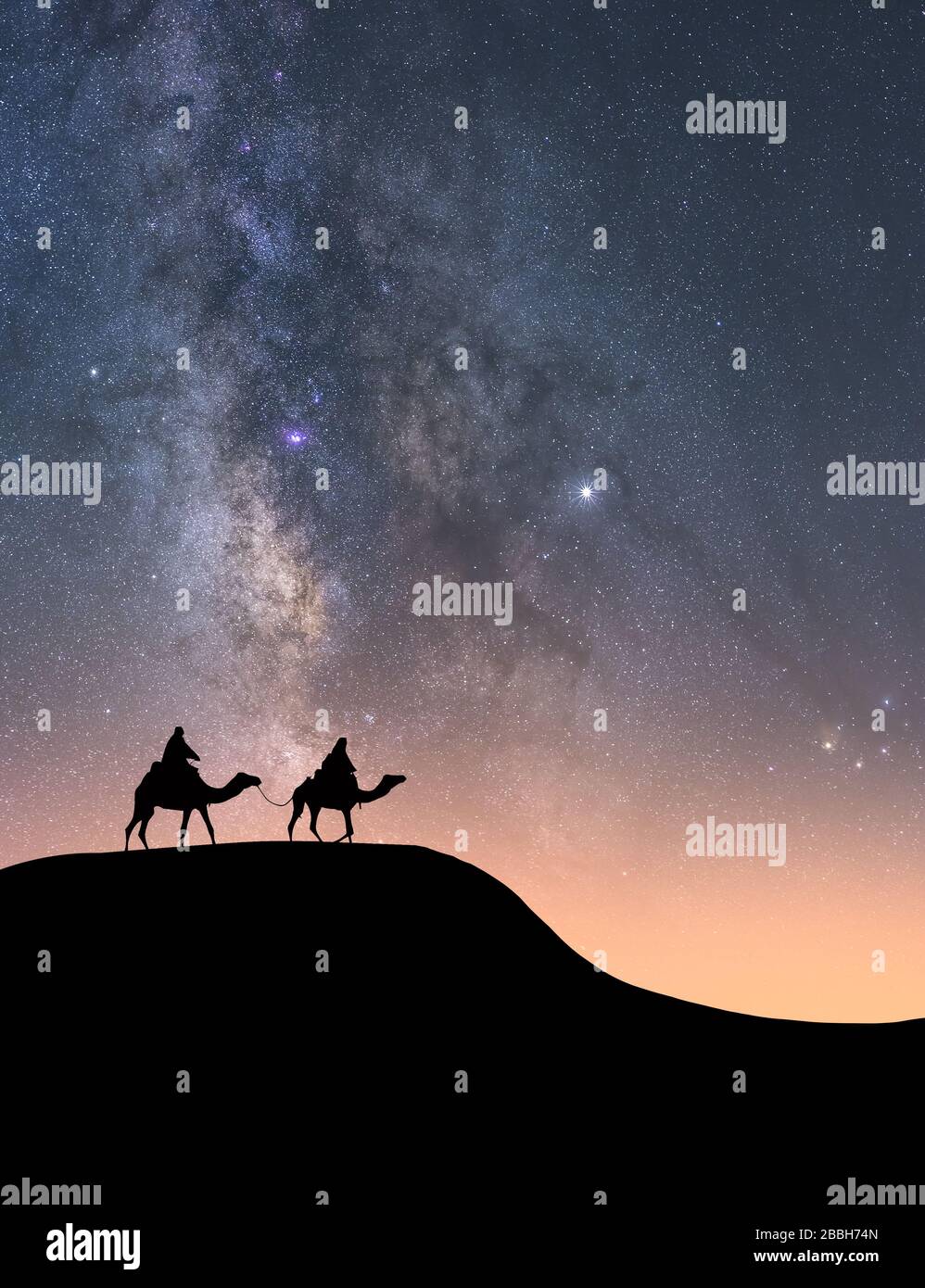 Silhouette di piloti sui loro cammelli su una duna del deserto di notte con la Via Lattea in background Foto Stock