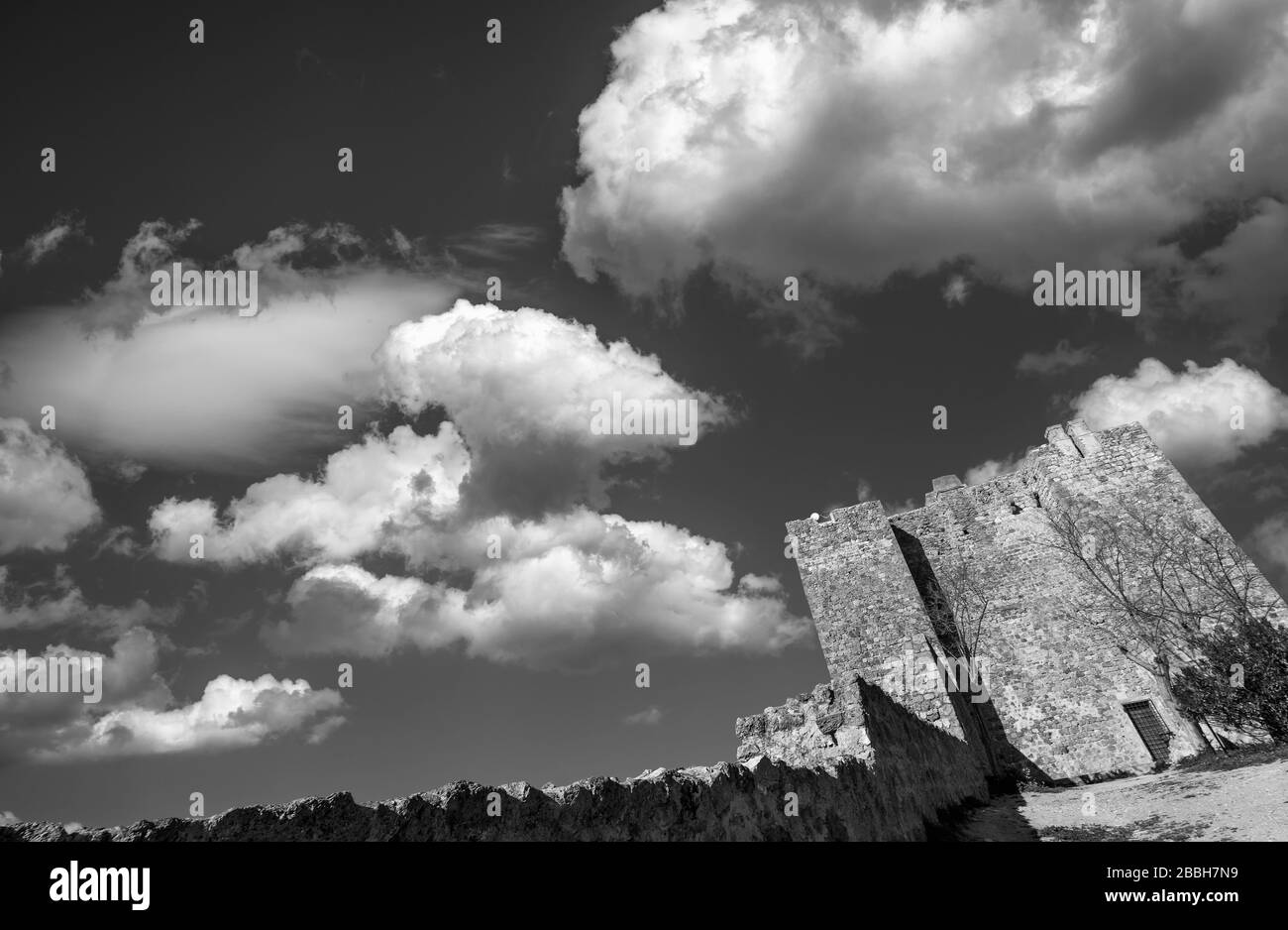 La Rocca Aldobrandesca di Talamone, Grosseto, Toscana, Italia, contro un cielo drammatico e pittoresco in bianco e nero Foto Stock
