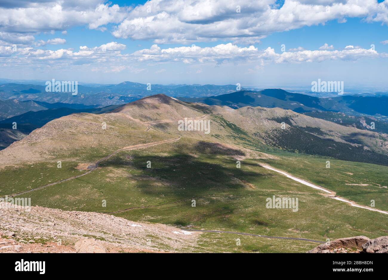 Paesaggio di prati verdi e colline ondulate con vista massiccia verso Denver dal Monte Evans Scenic Byway in Colorado Foto Stock