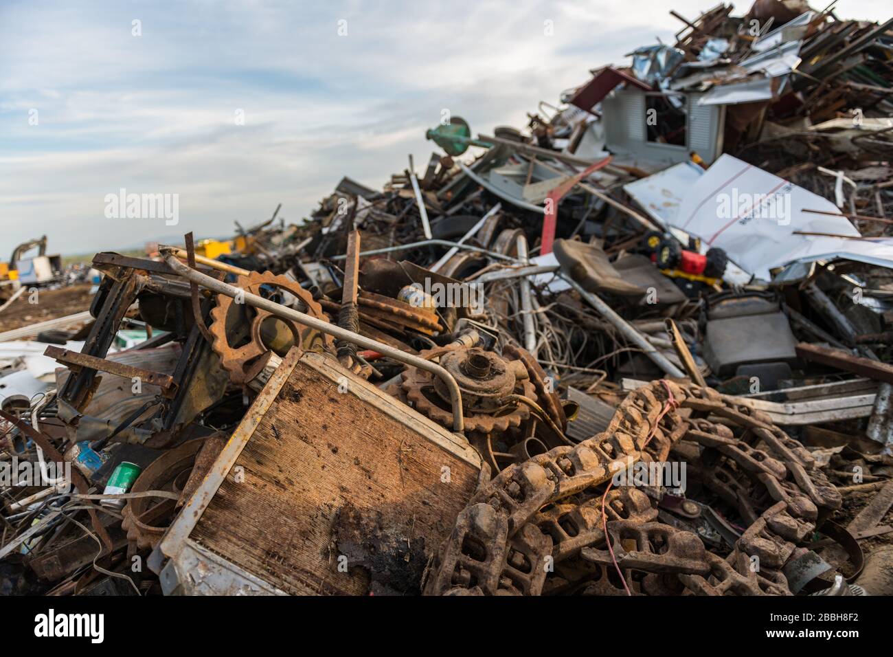 Ingranaggi, catene e altri rifiuti metallici in un cantiere di scarto Foto Stock