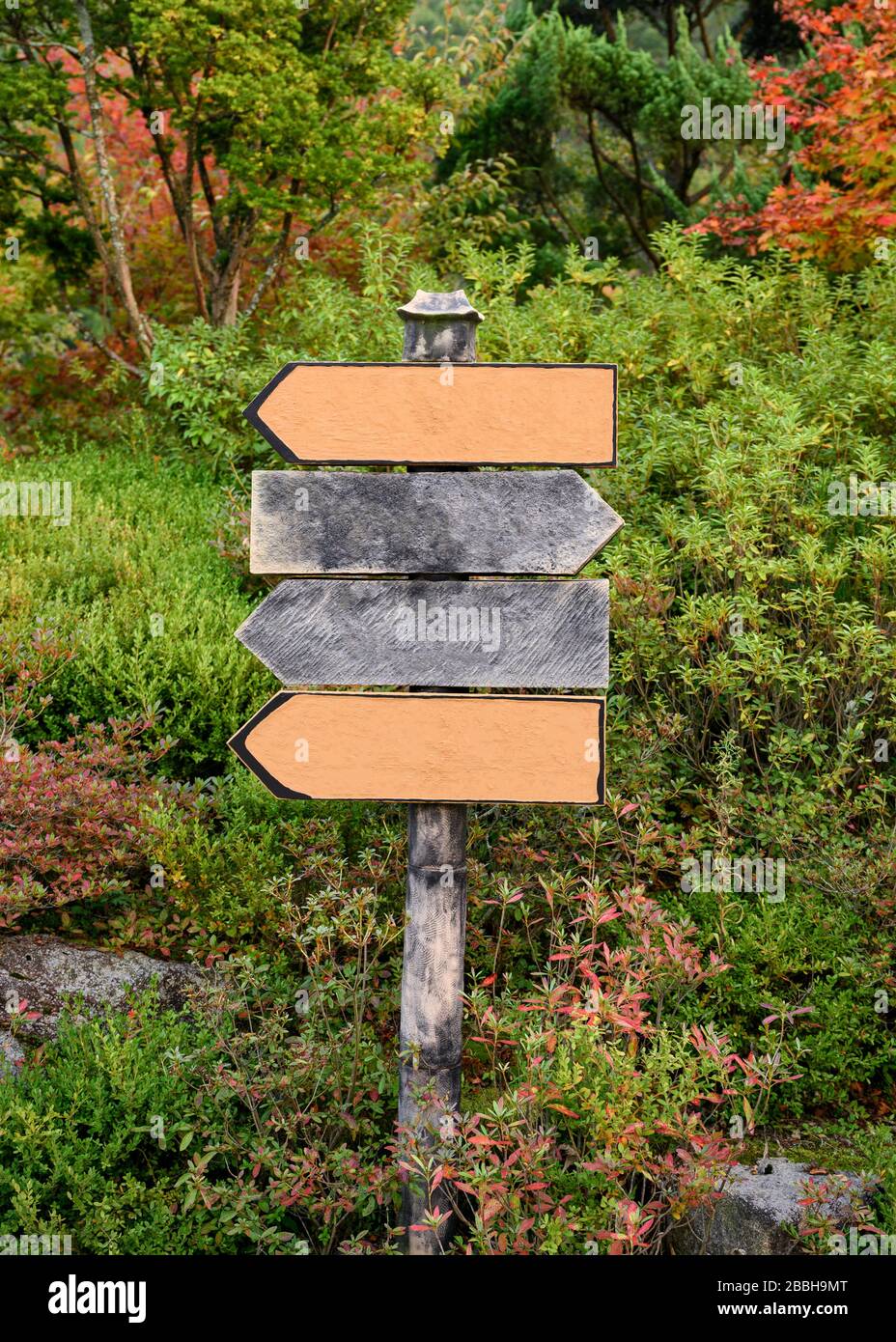 Frecce in legno cartello in giardino ornamentale Foto Stock