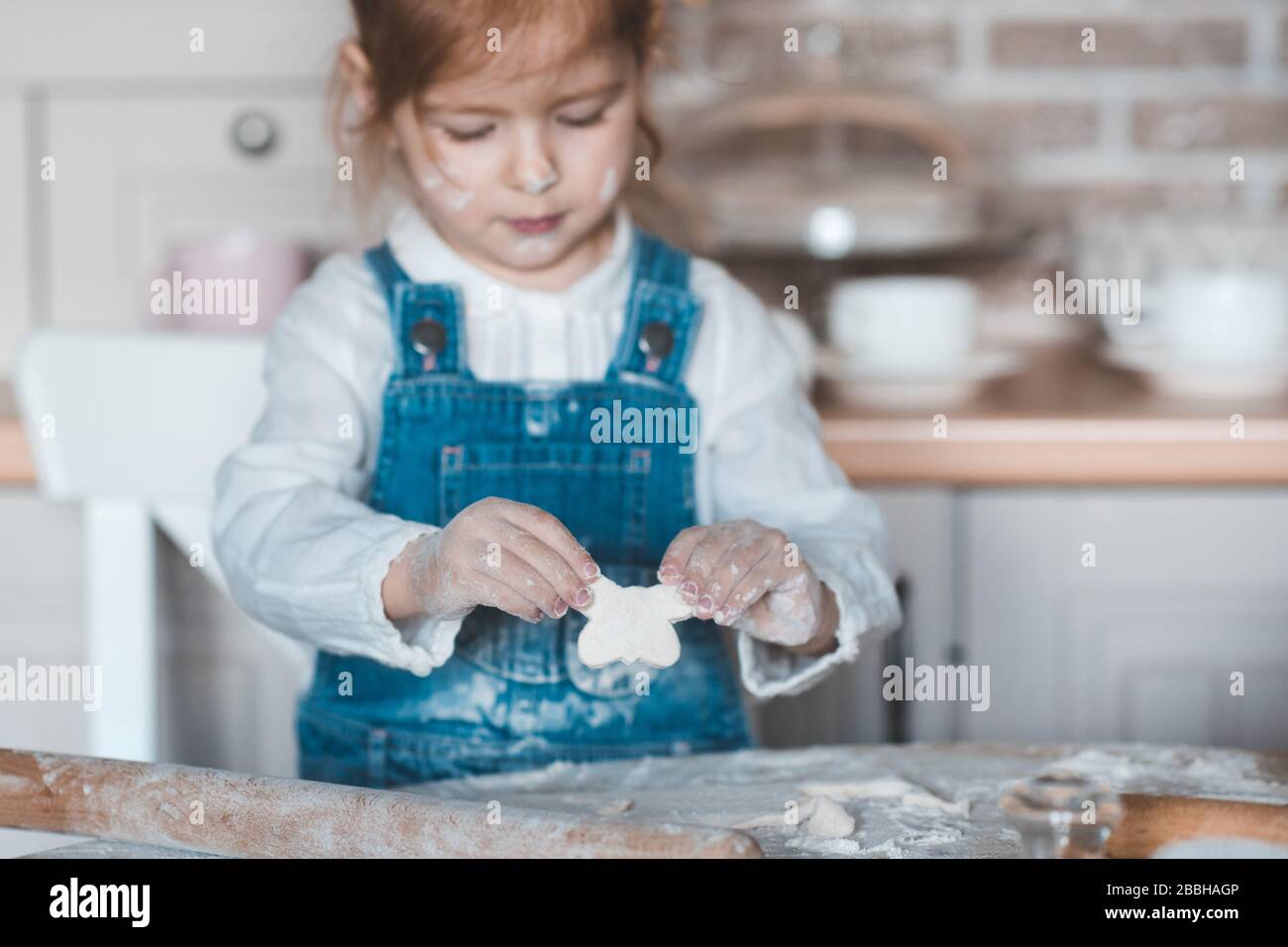 Bambina 3-4 anni che fa biscotti con pasta in cucina primo piano. Cucinare  i bambini a casa. Infanzia Foto stock - Alamy