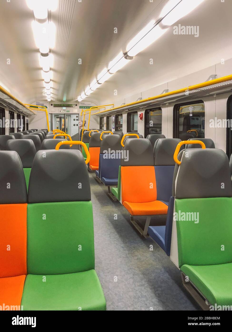 Prospettiva di una carrozza vuota con posti luminosi multicolore Foto Stock