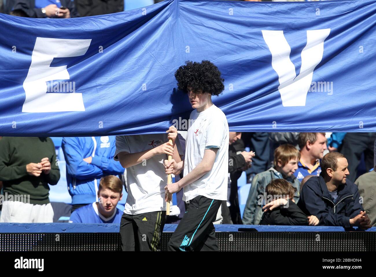 Portacolori di bandiera di Everton indossando una parrucca ispirata di Marouane Fellaini, prima del gioco Foto Stock